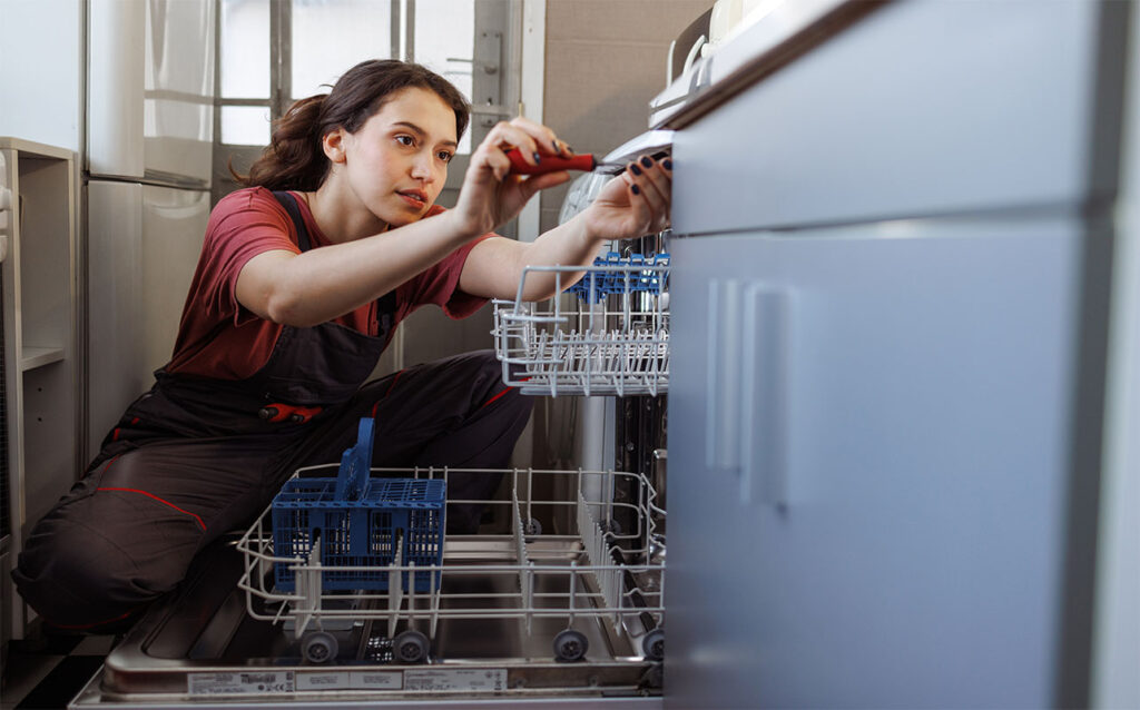 A repairwoman installing the dishwasher