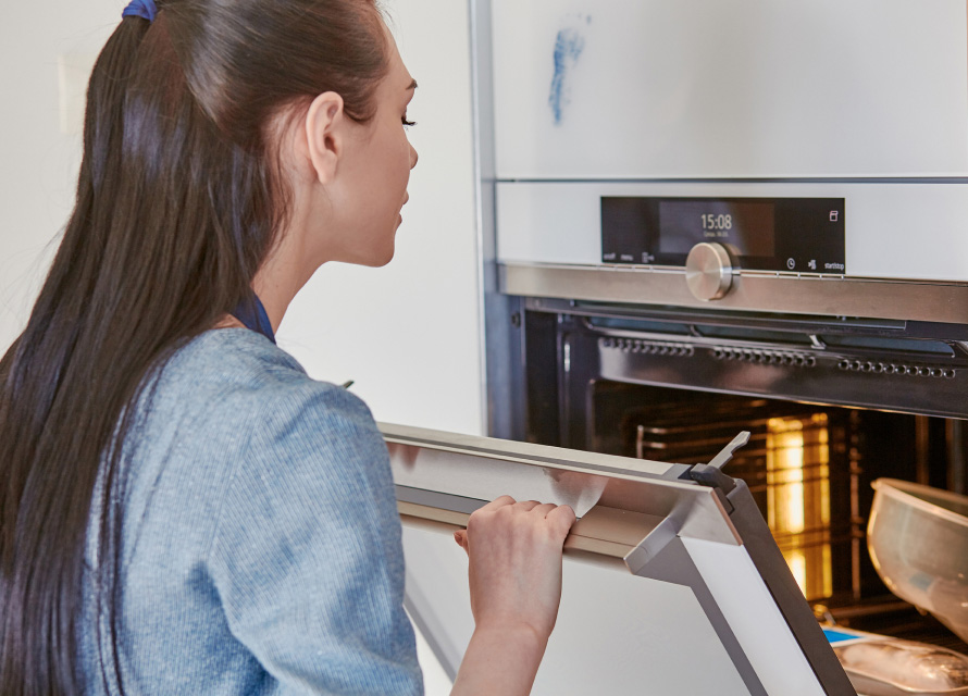 Woman Checking for oven Blockages